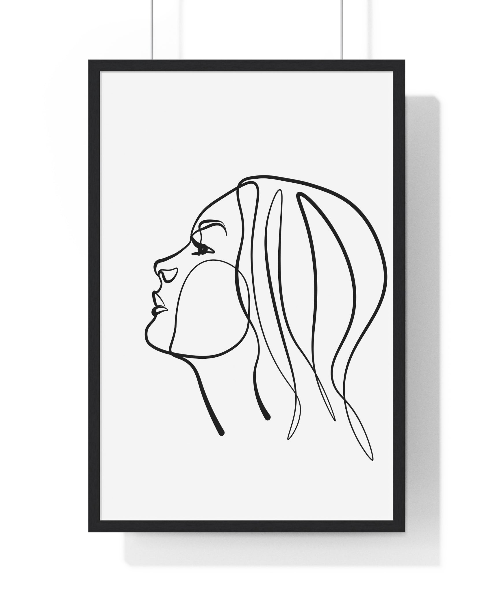 Framed line art of a woman's profile on a white wall