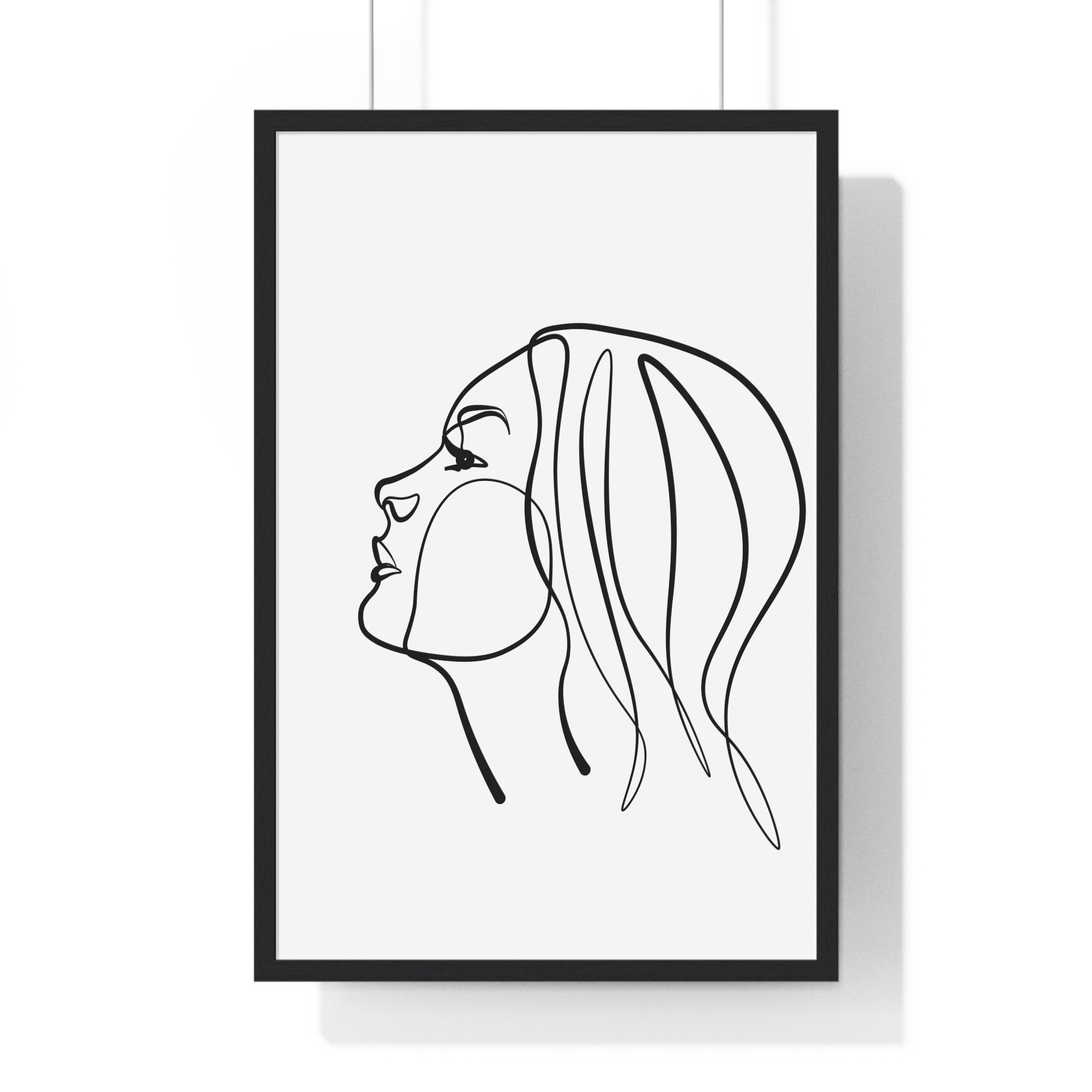 Framed line art of a woman's profile on a white wall